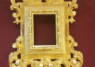 Marco tallado en madera de cedro y dorado con oro fino con grabado.